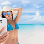 Summer beach vacation girl taking fun phone selfie